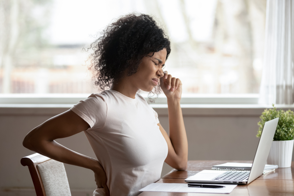 woman sitting at desk experiencing back pain